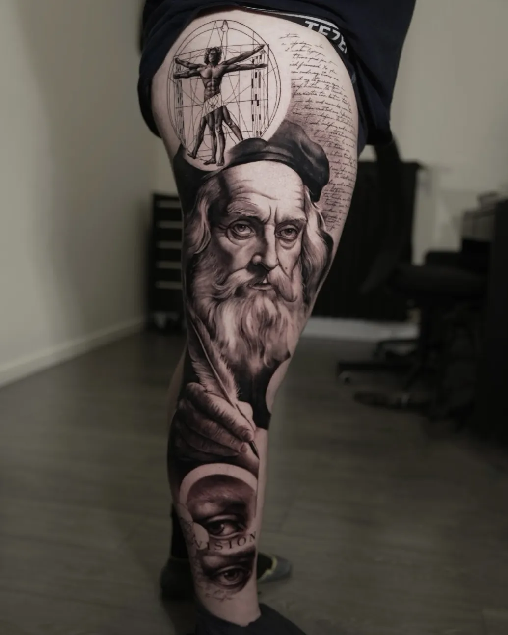 Leonardo da Vinci black and grey leg tattoo